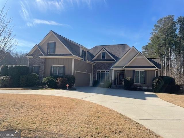 craftsman house with a garage, a front yard, and driveway