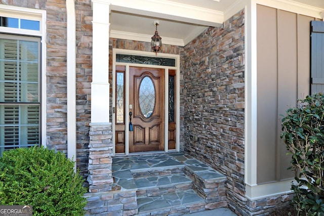 view of exterior entry with stone siding and a porch