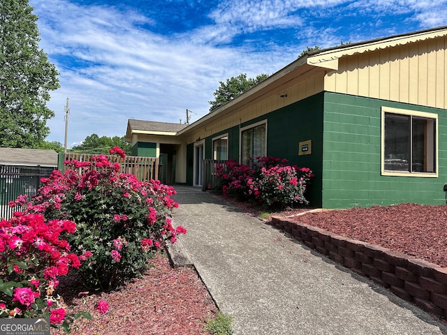 view of home's exterior featuring fence and concrete block siding