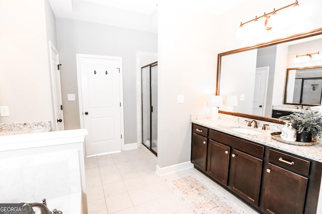 bathroom featuring baseboards, a shower stall, vanity, and tile patterned floors