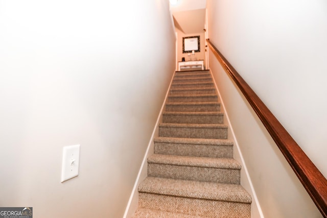 stairway with carpet floors and baseboards