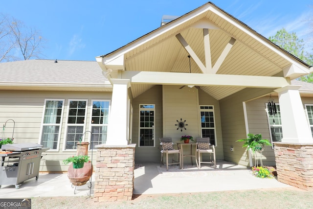 back of house featuring roof with shingles and a patio area