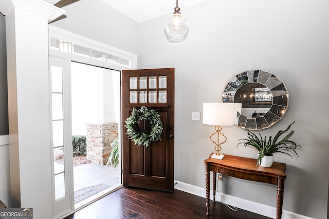 foyer featuring baseboards and dark wood finished floors