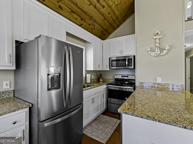 kitchen with appliances with stainless steel finishes, white cabinetry, and light stone counters