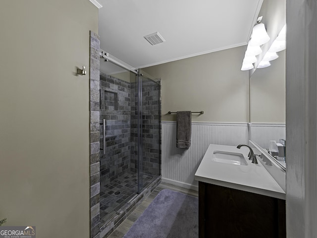 bathroom with a stall shower, visible vents, wainscoting, wood finished floors, and vanity