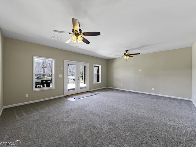 carpeted spare room with baseboards, visible vents, ceiling fan, and french doors