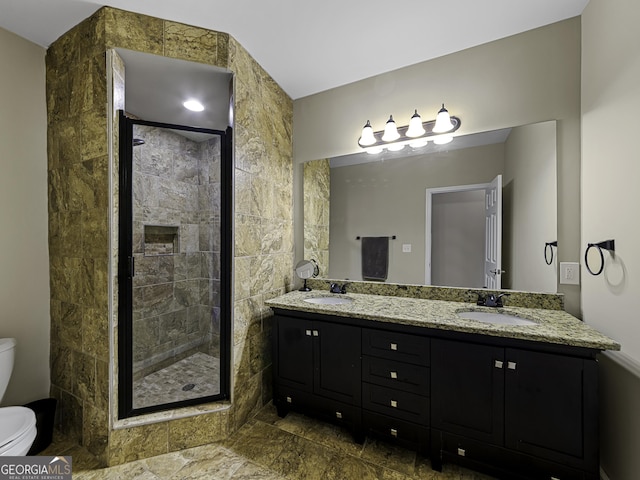 bathroom featuring toilet, a stall shower, and a sink