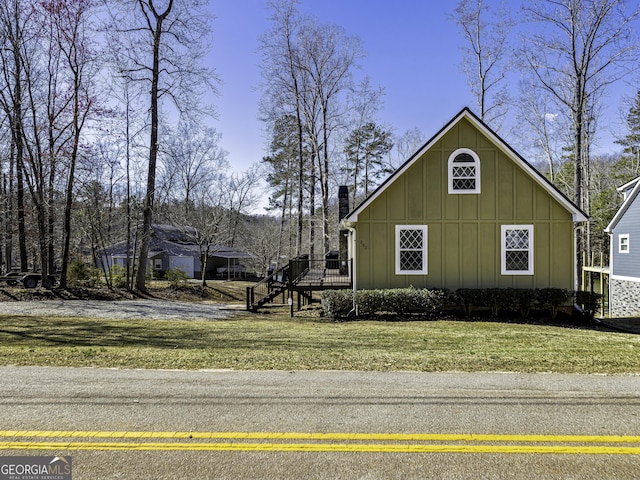 view of home's exterior featuring a yard, board and batten siding, and a chimney