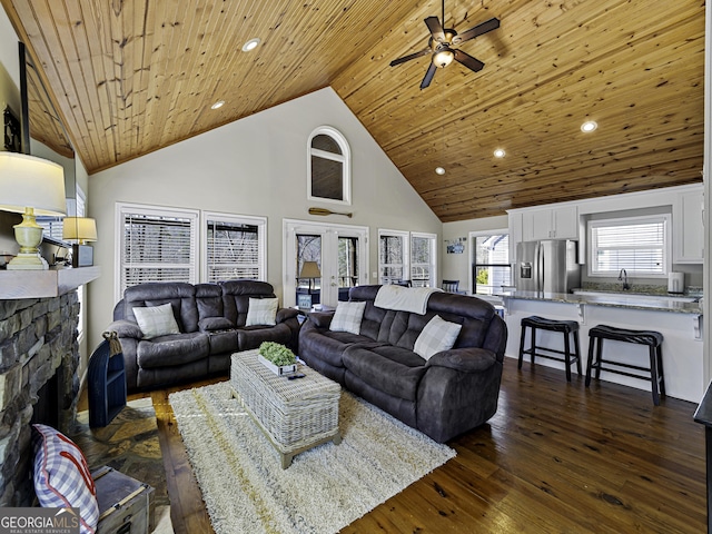 living area with high vaulted ceiling, dark wood-type flooring, a fireplace, wood ceiling, and french doors