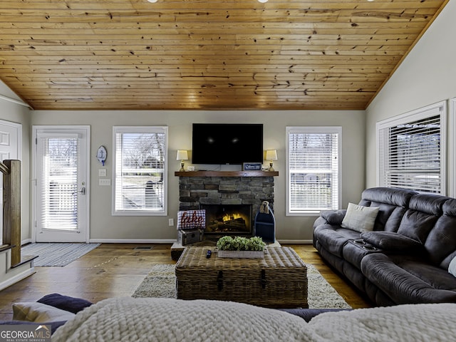 living room with a wealth of natural light, vaulted ceiling, a fireplace, and hardwood / wood-style flooring