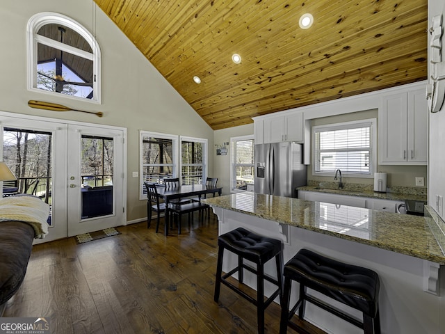 kitchen featuring french doors, dark wood-style flooring, wood ceiling, white cabinets, and stainless steel fridge