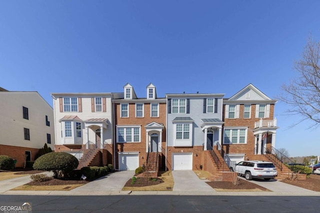 multi unit property with driveway, brick siding, and an attached garage