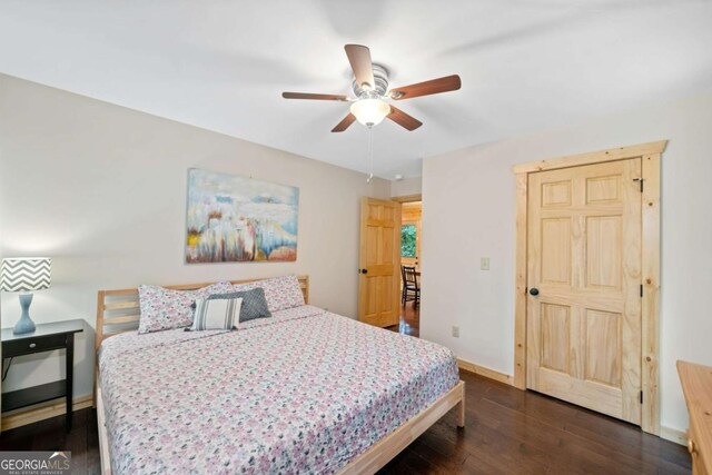 bedroom featuring ceiling fan, baseboards, and dark wood-style flooring