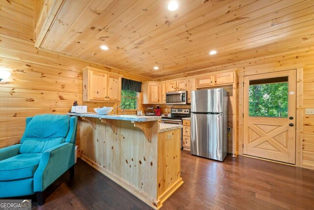 kitchen with a breakfast bar area, appliances with stainless steel finishes, dark wood-type flooring, wood ceiling, and a peninsula