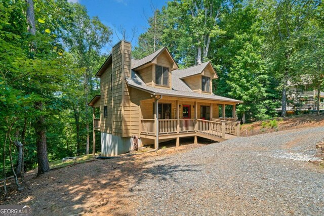 chalet / cabin with a porch and a chimney