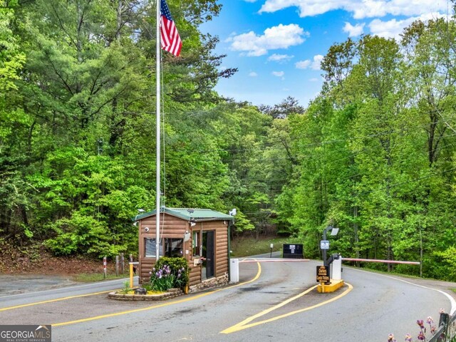 view of street with a gated entry and a forest view