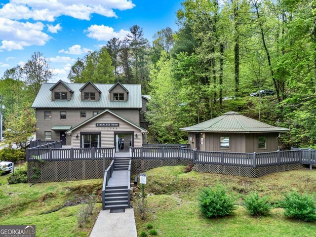 view of front of home featuring metal roof, a deck, and stairs