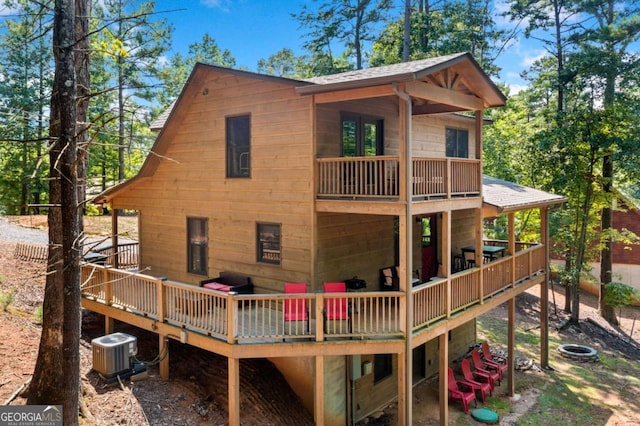 rear view of property featuring a deck and central air condition unit