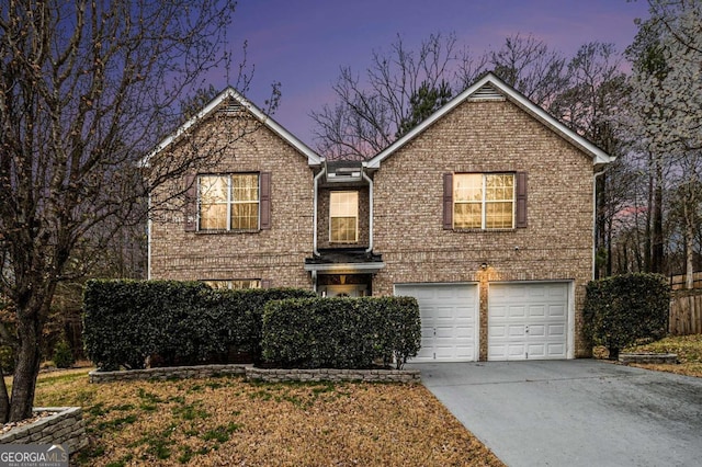 traditional home with a garage, concrete driveway, and brick siding