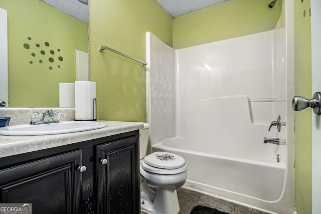 bathroom featuring toilet,  shower combination, a textured ceiling, and vanity