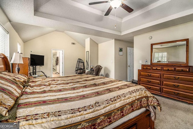 bedroom with carpet floors, a raised ceiling, visible vents, a ceiling fan, and vaulted ceiling