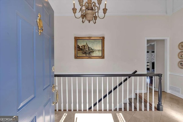 interior space featuring a notable chandelier, visible vents, ornamental molding, baseboards, and tile patterned floors