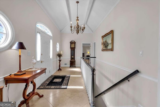 foyer entrance featuring light tile patterned floors, lofted ceiling, a notable chandelier, visible vents, and baseboards