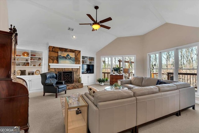 carpeted living area with ceiling fan, a stone fireplace, visible vents, built in features, and vaulted ceiling