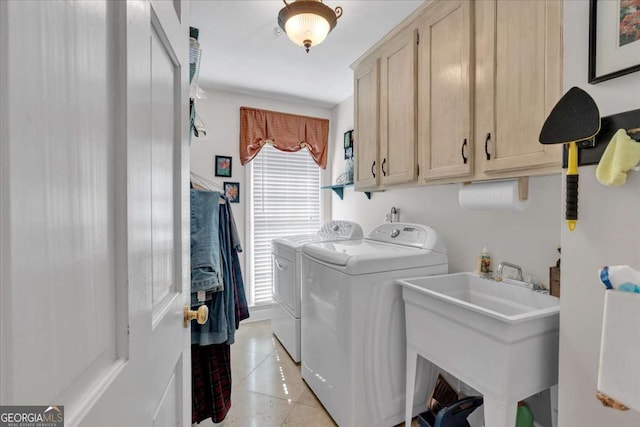 laundry room featuring cabinet space, independent washer and dryer, a sink, and light tile patterned floors