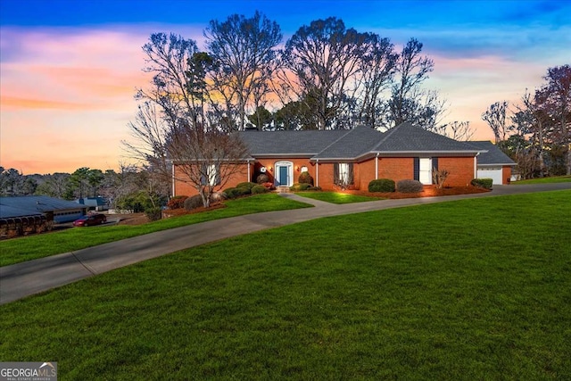 single story home featuring a garage, concrete driveway, and a front yard