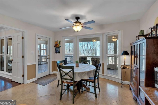 dining space featuring a ceiling fan, baseboards, and light tile patterned floors