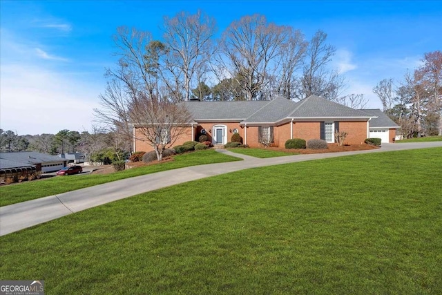 ranch-style home featuring a garage, driveway, and a front lawn