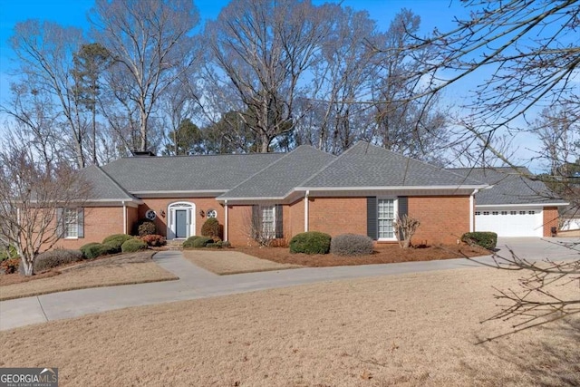 ranch-style house with driveway, brick siding, and roof with shingles