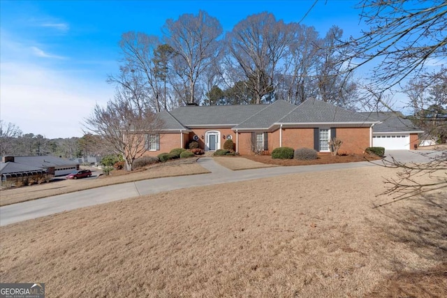 ranch-style home with concrete driveway, brick siding, and an attached garage