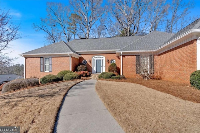 ranch-style house with a shingled roof and brick siding