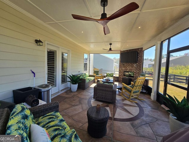 view of patio / terrace with ceiling fan and an outdoor living space with a fireplace