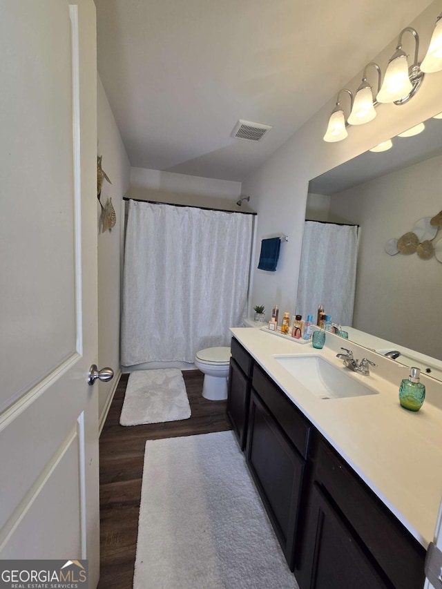 bathroom featuring visible vents, vanity, toilet, and wood finished floors