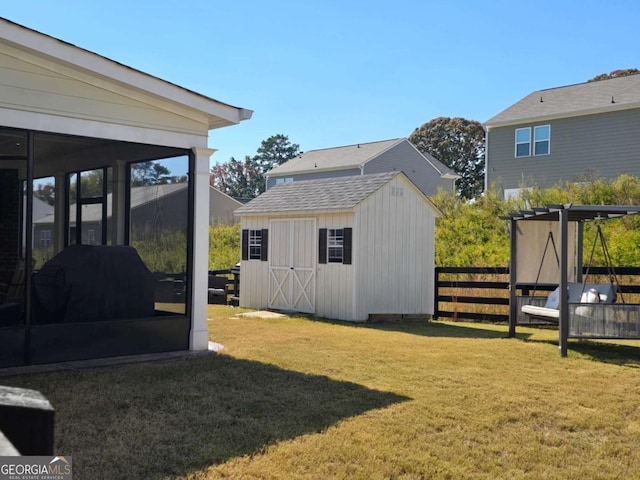 view of shed with fence and a sunroom