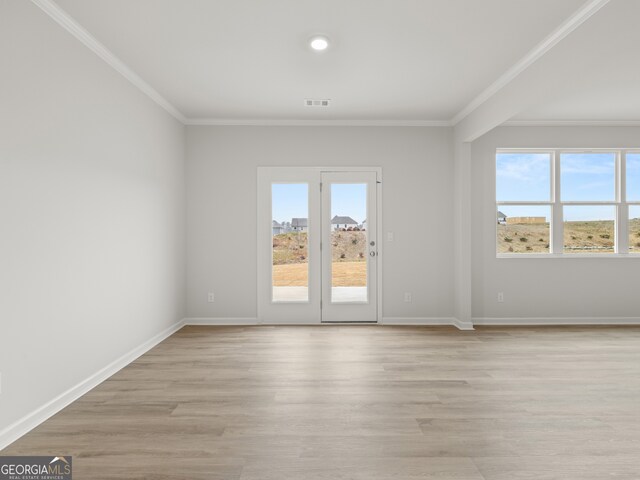 unfurnished room with baseboards, light wood-type flooring, and crown molding