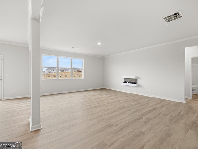 unfurnished living room featuring light wood finished floors, visible vents, and baseboards