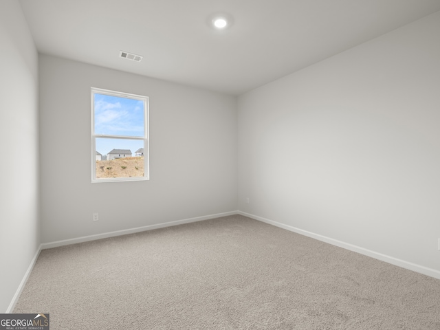 empty room featuring baseboards, visible vents, and carpet flooring