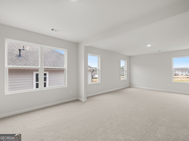 empty room with carpet floors, recessed lighting, visible vents, and baseboards