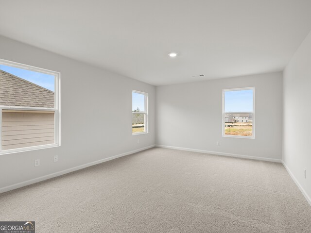 spare room featuring light carpet, visible vents, baseboards, and recessed lighting