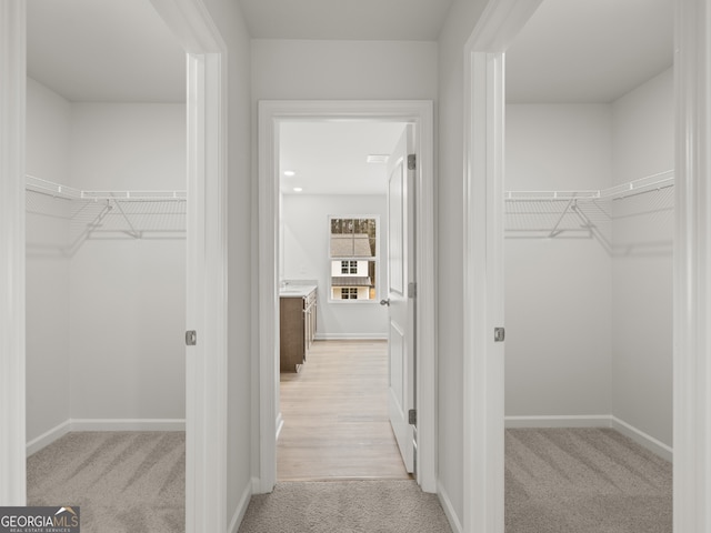 spacious closet featuring light colored carpet