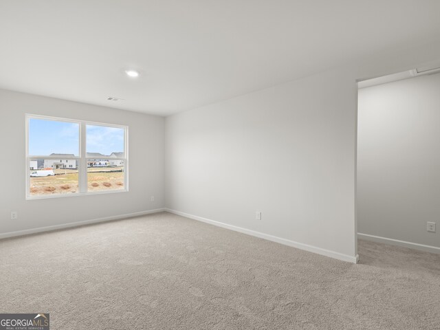 carpeted empty room with visible vents and baseboards