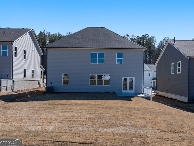 back of property featuring a shingled roof, central AC unit, and french doors