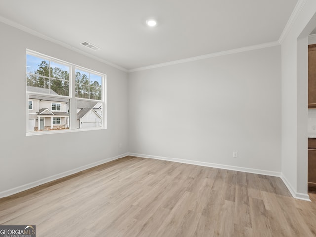 interior space with baseboards, light wood-type flooring, visible vents, and crown molding