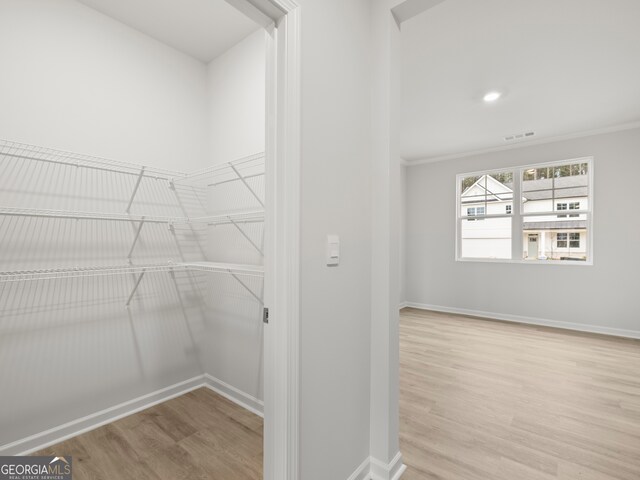 walk in closet with visible vents and wood finished floors