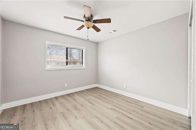 unfurnished room featuring ceiling fan, light wood-type flooring, visible vents, and baseboards