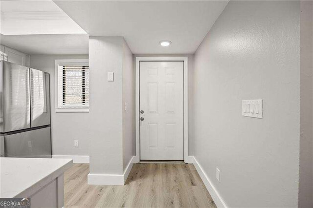 doorway featuring light wood-type flooring and baseboards